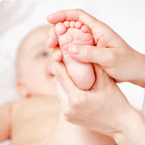 Réflexologie pédiatrique des pieds – toucher doux sur les zones réflexes plantaires
